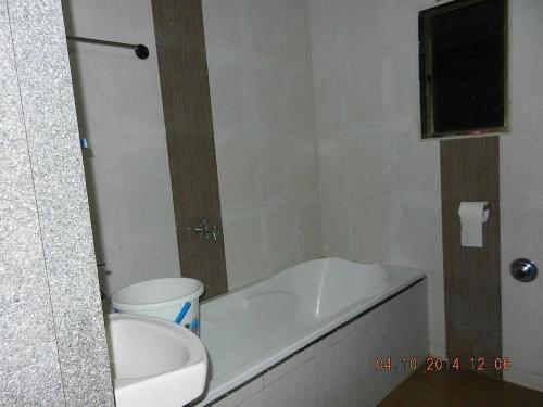 een badkamer met een bad, een toilet en een wastafel bij SS Resort Near Jaysagar Lake in Jawhār