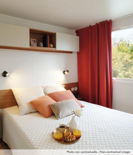 - une chambre avec un lit et un plateau de nourriture dans l'établissement Camping Officiel Siblu Les Dunes de Contis, à Saint-Julien-en-Born