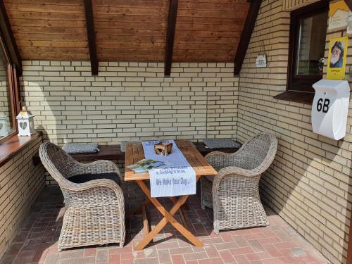 a table with chairs and a cat on a sign on it at Ferienhäuser Seemannsgarn in Friedrichskoog-Spitz