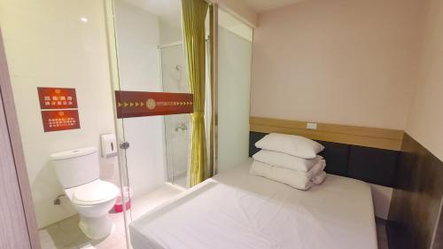 a small bathroom with a toilet and some towels at Chao She Hotel in Kaohsiung