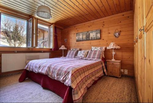 um quarto com uma cama num chalé de madeira em Chalet Soldanella 10 guests Gstaad em Gstaad