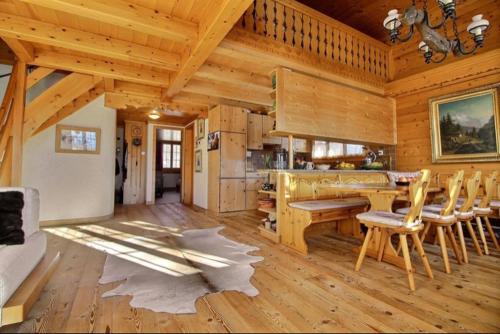 a kitchen with a table and chairs in a cabin at Chalet Soldanella 10 guests Gstaad in Gstaad