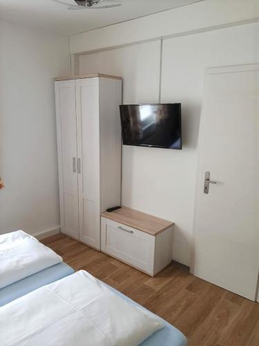 a bedroom with two beds and a dresser and a cabinet at Pension Förster in Glauchau