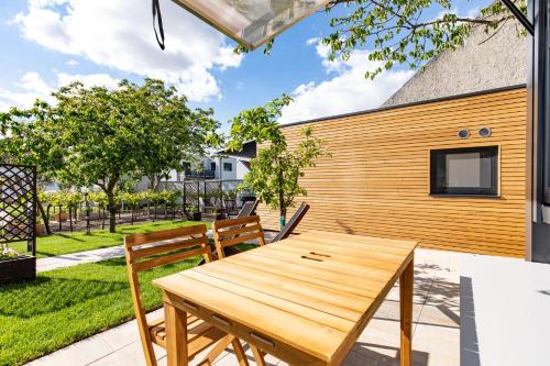 a patio with a wooden table and chairs at Uiferhäuser in Illmitz