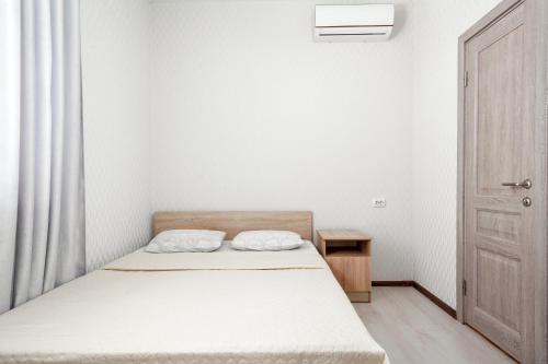 アドレルにあるGuest house Nikaの白い小さなベッドルーム(ベッド1台、ドア付)