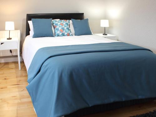 ダンガノンにあるKC Accommodationsのベッドルーム1室(大型ベッド1台、青いシーツ、枕付)
