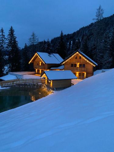 a house in the snow in front of a building at Bergseegut Chalet und Apartment in Wagrain