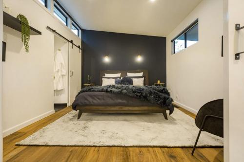 a bedroom with a bed and a black wall at Kudos Villas - Hepburn Springs in Hepburn Springs