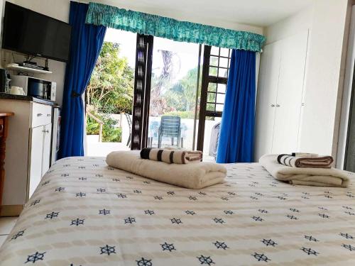 sypialnia z dużym łóżkiem z niebieskimi zasłonami w obiekcie Boathouse Bed & Biscuit - Lower Deck w mieście Margate