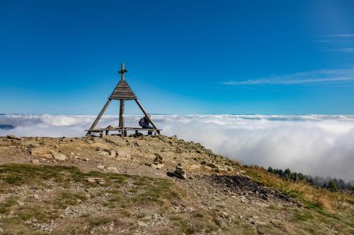 a cross on top of a hill with clouds at Apartment Wanderlust Gerlitzen in Kanzelhöhe