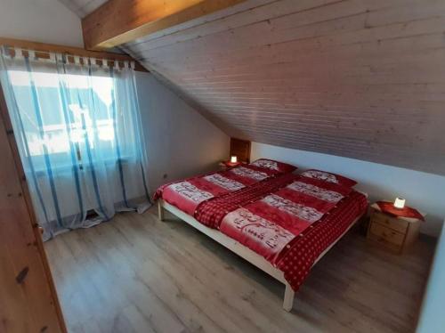 a bedroom with a bed with a red blanket at Ferienwohnung Berglen-Domizil in Kottweil