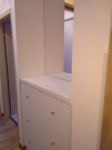 a white cabinet with a mirror on top of it at APARTMÁNY NA VÝSLUNÍ in Horní Maxov