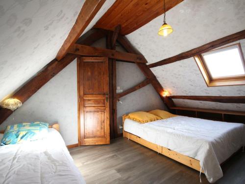 een slaapkamer met 2 bedden op een zolder bij Gîte Champsecret, 2 pièces, 3 personnes - FR-1-497-15 in Champsecret