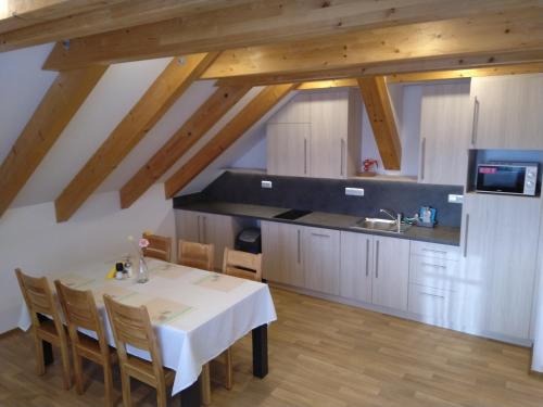 a kitchen with a white table and a kitchen with wooden ceilings at APARTMÁNY NA VÝSLUNÍ in Horní Maxov