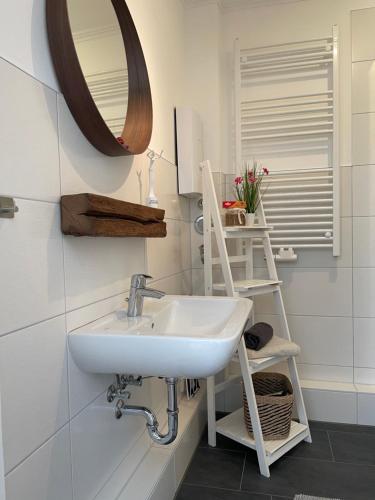 a bathroom with a sink and a mirror at Ostseestrand-Apartments in Ostseebad Nienhagen