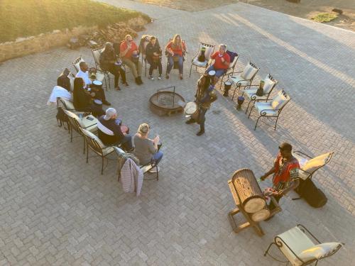 a group of people sitting in chairs on a patio at The Vaal Guesthouse in Oranjeville
