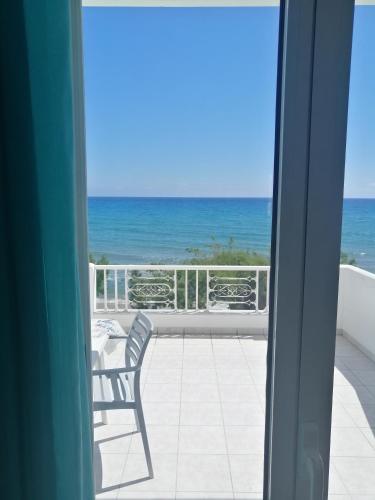 a room with a view of the ocean from a balcony at Coastal Apartment Christina 2 in Makry Gialos