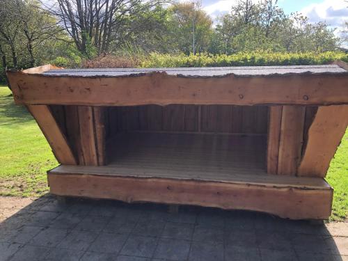un banc en bois avec un toit dans l'établissement Familiehuis Boysen Shelters, à Ribe
