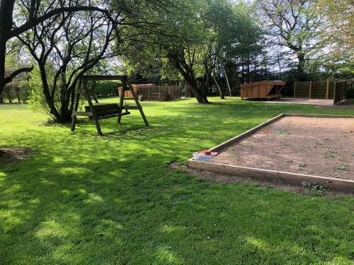a park with a swing set in the grass at Familiehuis Boysen Shelters in Ribe