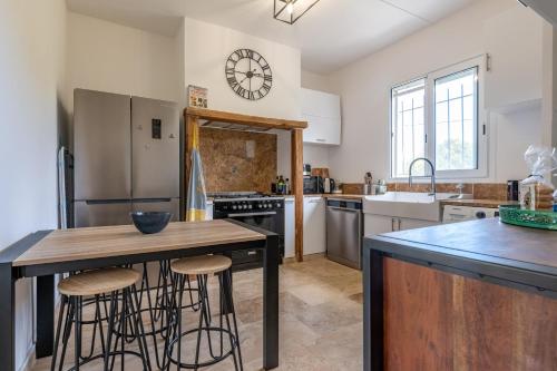 - une cuisine avec une table et des tabourets en bois dans l'établissement Résidence Poggiole, à San-Nicolao