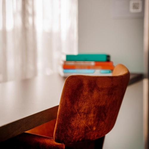 a chair sitting in front of a table with books at Olympic Hotel in Amsterdam