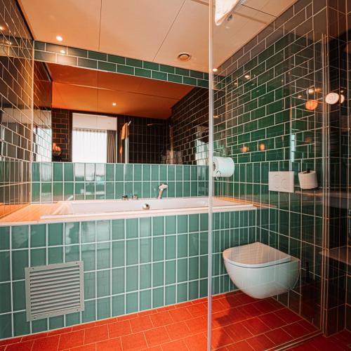 a bathroom with a tub and a toilet and a sink at Olympic Hotel in Amsterdam