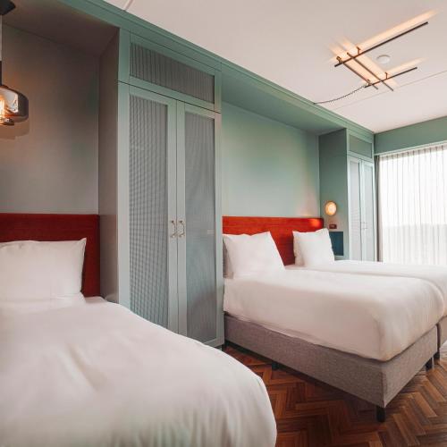 two beds in a room with two beds sidx sidx sidx at Olympic Hotel in Amsterdam