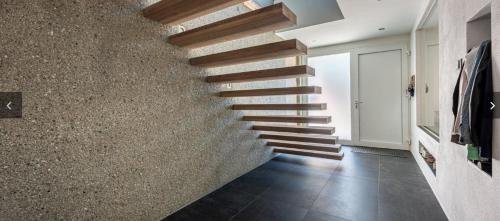 a staircase in a house with a stone wall at Alpin Chalet Arte in Söll