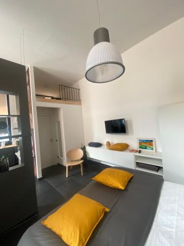 um quarto com uma cama com duas almofadas amarelas em Fashionhouse em La Spezia