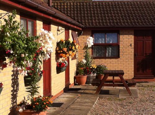 a wooden table in front of a house with flowers at The Star Inn in Nafferton