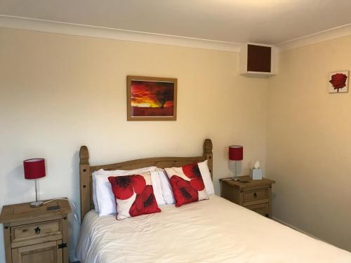 a bedroom with a bed with red pillows on it at The Star Inn in Nafferton