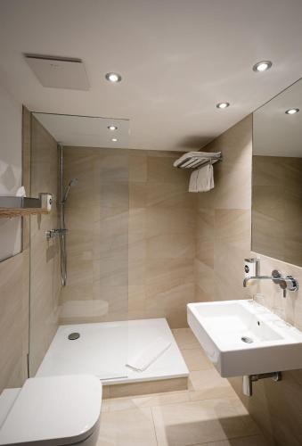 a bathroom with a white sink and a shower at Hotel Wetterstein in Munich