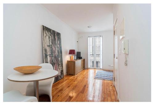 a white living room with a table and a room with a door at Cosy Alfama in Lisbon