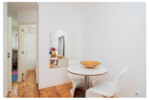 Habitación blanca con mesa y sillas blancas en Cosy Alfama, en Lisboa