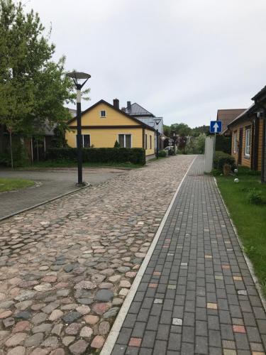 a cobblestone street in a residential neighborhood with houses at Daukanto apartamentai in Anykščiai