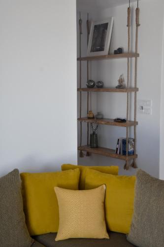 a couch with two yellow pillows and a shelf at Villa Nelleas in Adamas