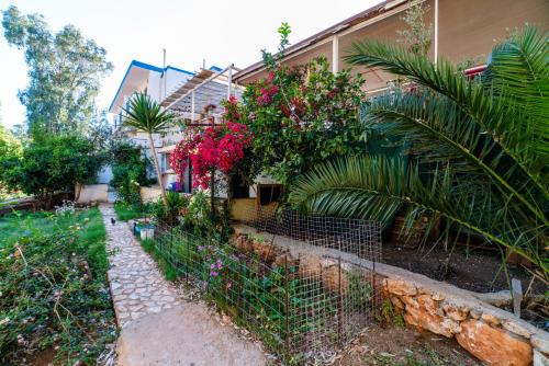 a fence in front of a house with flowers at Eucalyptus Pension in Patara