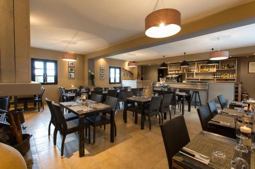 a dining room table with chairs and a large window at Hôtel - Restaurant U Santu Petru in Saint-Florent
