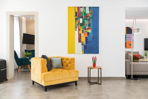 a living room with a yellow chair and a painting at M Mansion in Pefki Rhodes