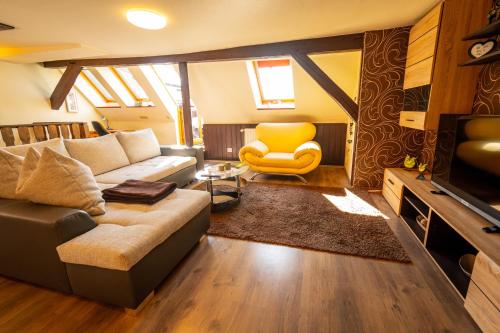 ein Wohnzimmer mit einem Sofa und einem gelben Stuhl in der Unterkunft Ferienhaus An der Postmeilensäule in Lübbenau