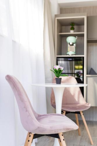 a pink chair and a glass table with a vase of flowers at M Mansion in Pefki Rhodes