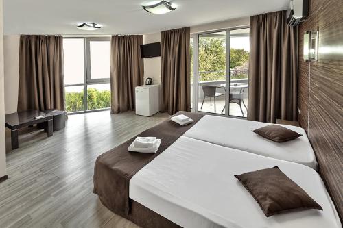 a large bedroom with a large bed and a table at Hotel Elit in Sandanski