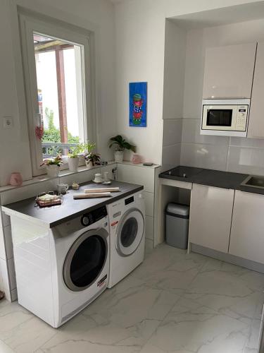 a kitchen with a washing machine and a microwave at Gästehaus Kühnle in Bad Wildbad