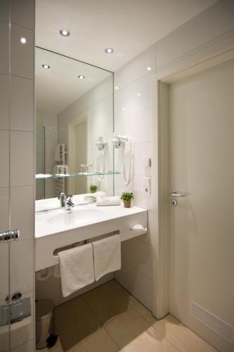 a bathroom with a sink and a mirror at Landhotel Alte Mühle in Ostrach