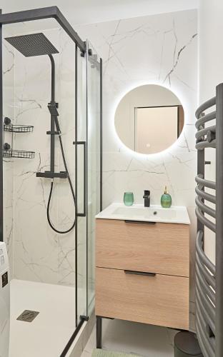 une salle de bain avec un lavabo et une douche avec un miroir dans l'établissement L'Etoile du Sud - Les Maisons de Madeleine, à Nantes