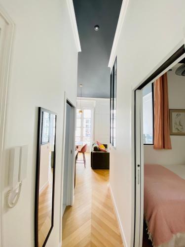 Ce petit appartement comprend un lit et une porte en verre. dans l'établissement L'Etoile du Sud - Les Maisons de Madeleine, à Nantes