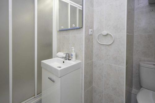 Baño blanco con lavabo y aseo en Estudio Voramar Playa San Juan, en El Campello