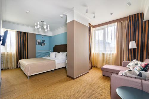 a hotel room with a bed and a couch at Business Hotel Diplomat in Nizhny Novgorod