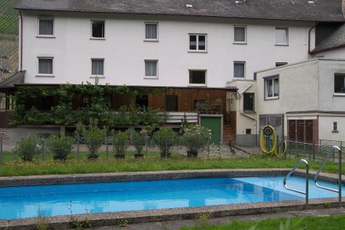 a house with a swimming pool in front of a building at Hotel Dampfmühle in Enkirch