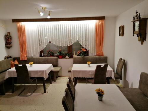 a dining room with two tables and couches at Ferienwohnung ENZTALPERLE in Enzklösterle